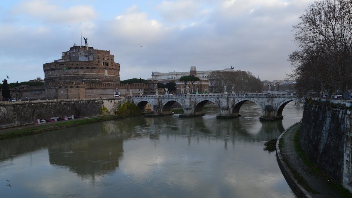 Castel Sant'Angelo and bridge reflected in the calm waters of the Tiber River