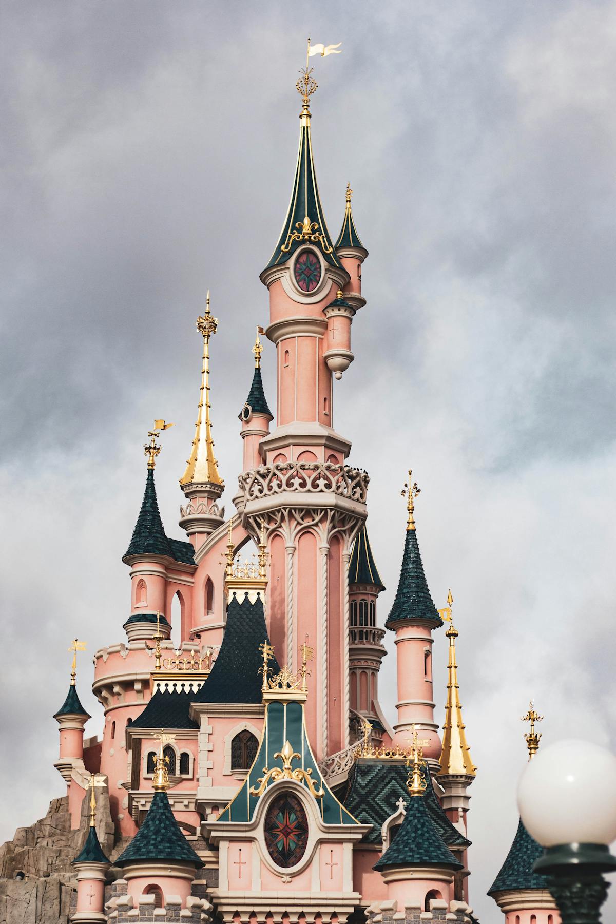 Sleeping Beauty Castle at Disneyland Paris under dramatic grey clouds