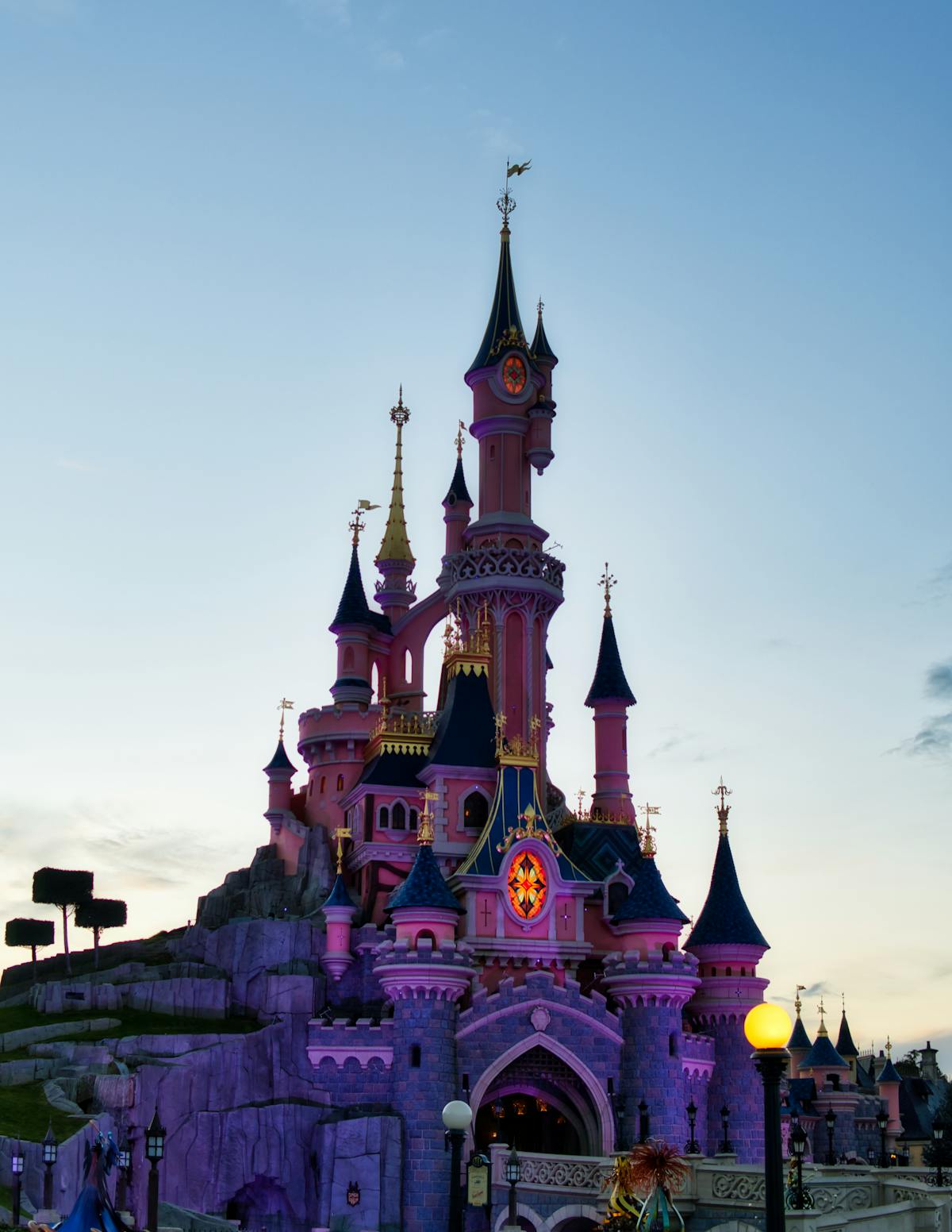 Disneyland Paris castle illuminated during twilight with its towers glowing