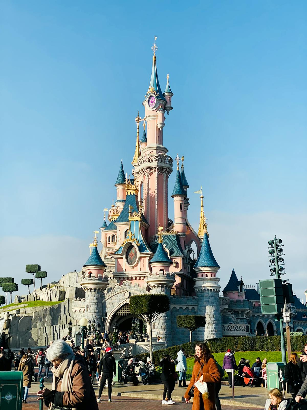 Visitors walking toward Sleeping Beauty Castle at Disneyland Paris on a sunny day