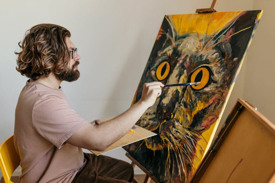 Artist painting a colorful cat portrait at watercolor workshop