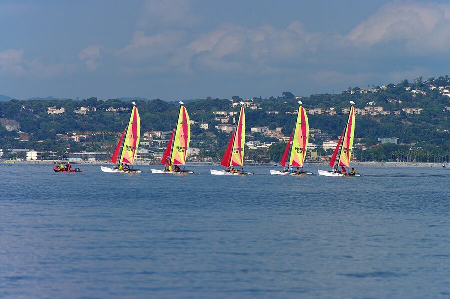 Two catamarans sailing on the open ocean under clear sky