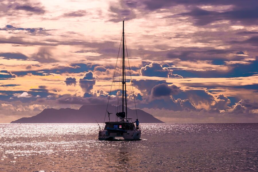 Catamaran with white sails on turquoise sea