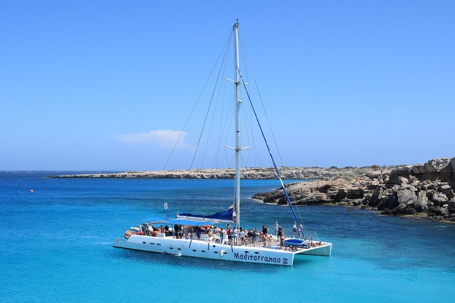 Catamaran boat cruising in turquoise lagoon waters