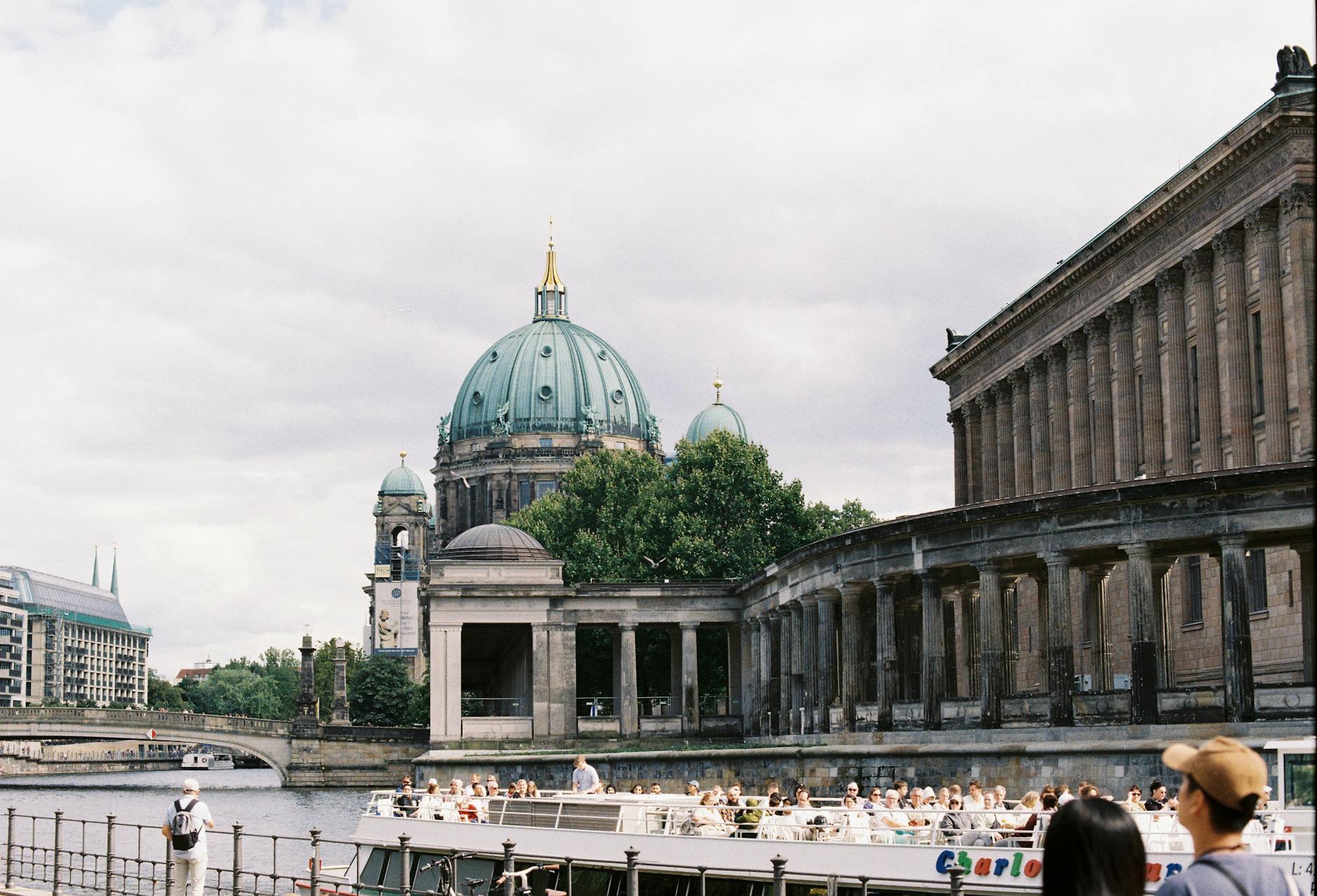 A river cruise boat passing in front of Berlin Cathedral