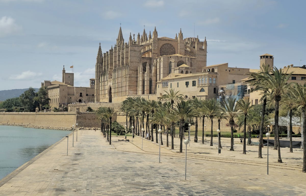 Palma Cathedral and the waterfront promenade viewed from across the harbour in Mallorca Spain