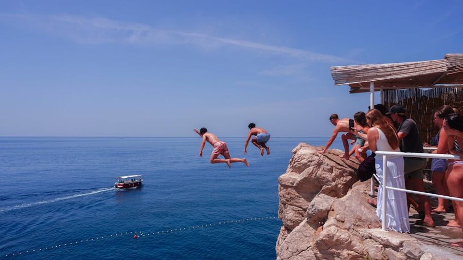 People cliff diving into Adriatic Sea Croatia