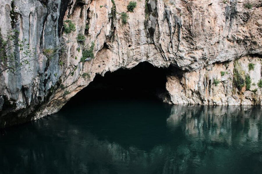 Cave entrance reflected in clear water