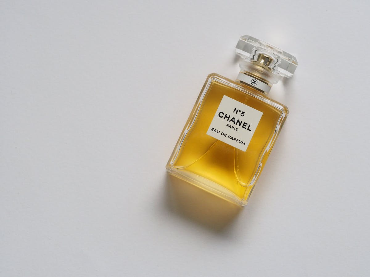 Elegant gold-toned eau de parfum bottle on white background
