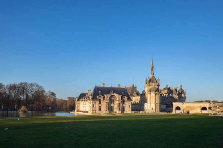 Chateau de Chantilly castle exterior with water reflections