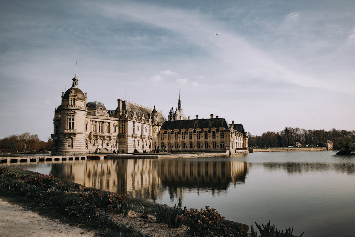Majestic Chateau de Chantilly with reflection on tranquil lake