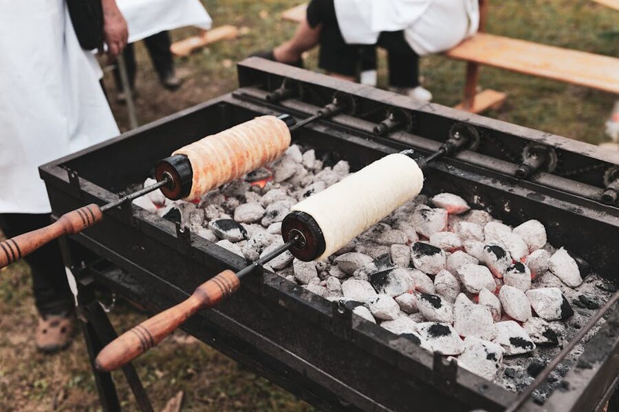 Chimney cakes baking over charcoal at outdoor event