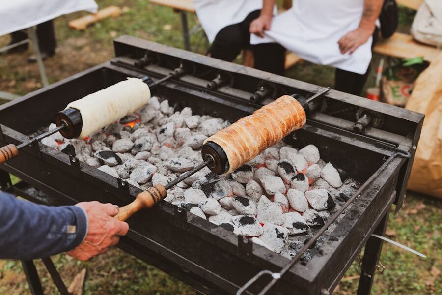 Chimney cake rotating on spit over hot coals