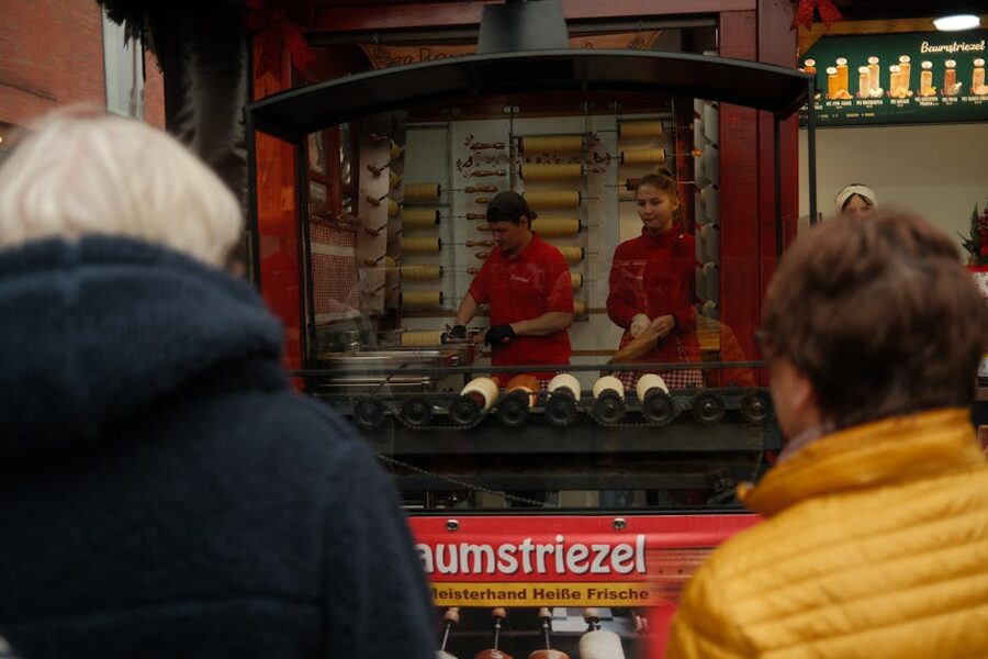 Street vendors making chimney cakes at Budapest market
