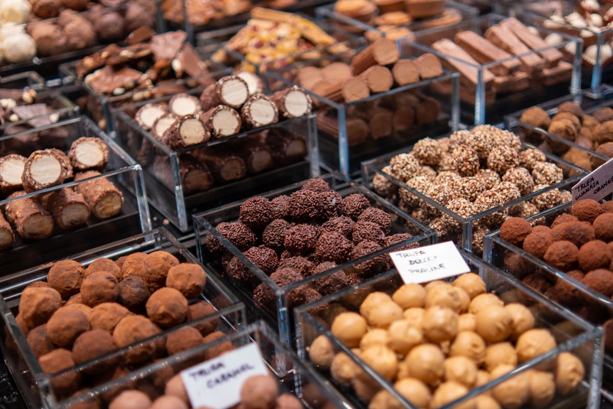 Selection of chocolate truffles in clear containers at a market