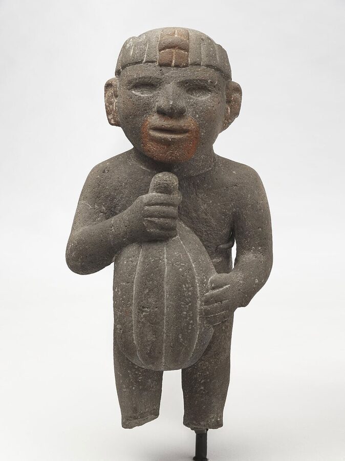 Aztec stone figure carrying a cacao pod