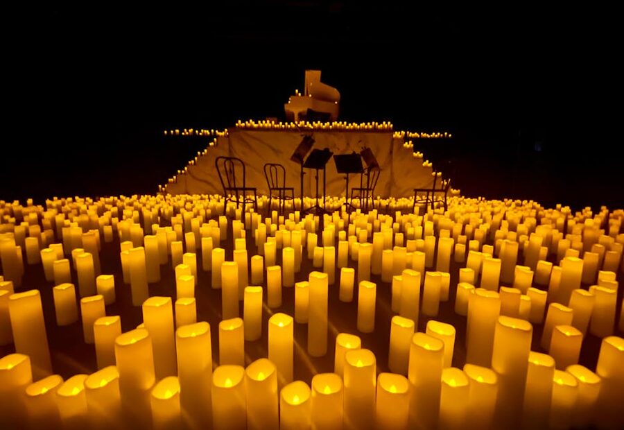 Candlelit stage with grand piano and music stands