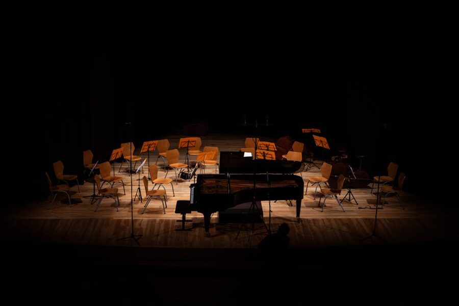Empty stage with grand piano under stage lights