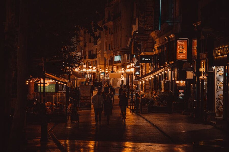 Illuminated Budapest alley at night with people walking