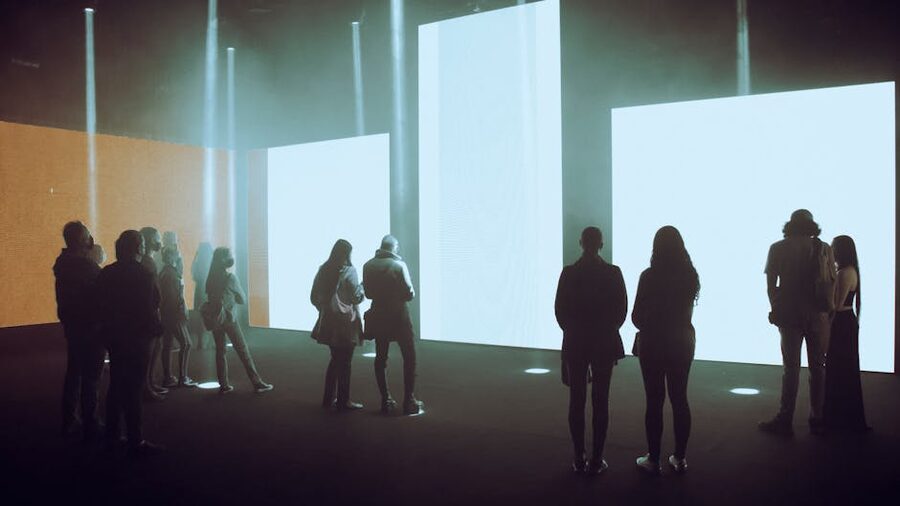 Visitors walking past illuminated screens in an immersive digital art venue