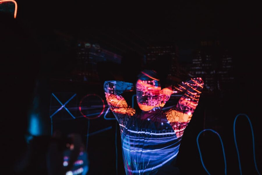 Person in dark room with neon projections