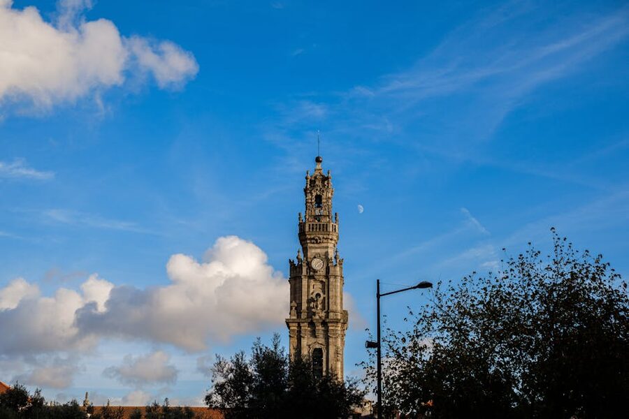 Clerigos Tower against blue sky with trees