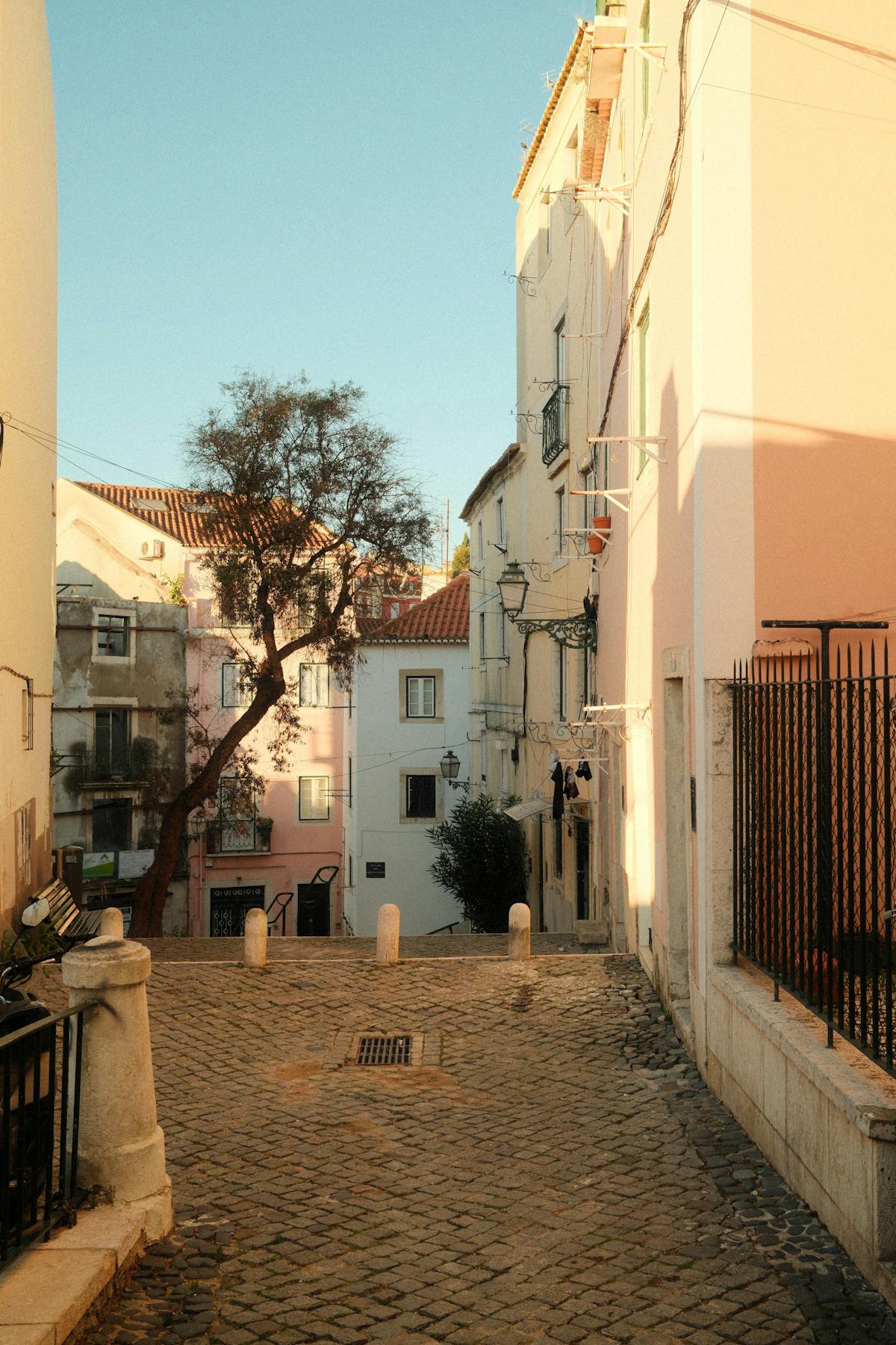 Colorful Lisbon street with yellow and blue buildings under a clear blue sky