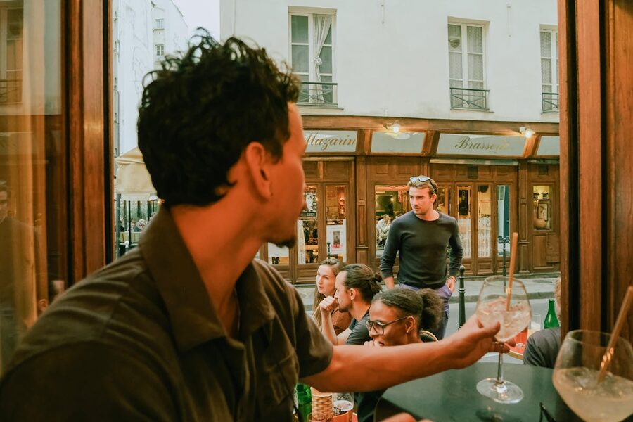 People at a casual gathering at a Parisian cafe in autumn