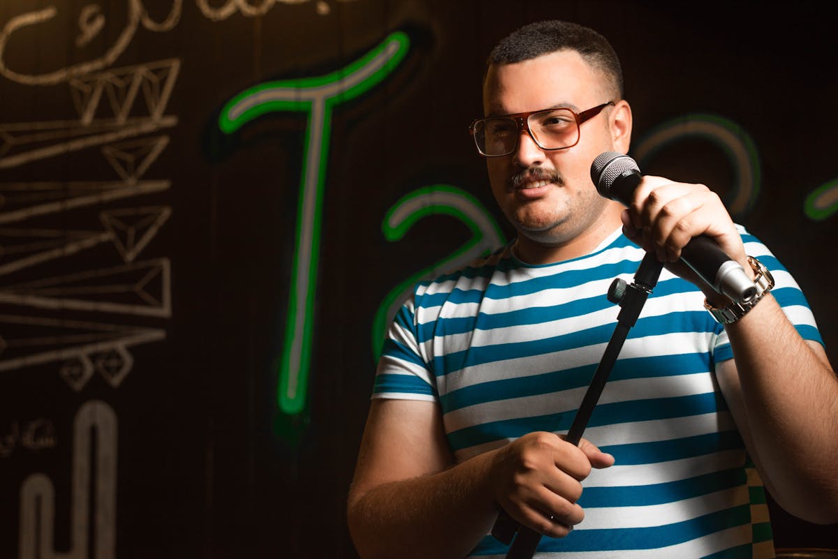 Stand-up comedian holding microphone on stage