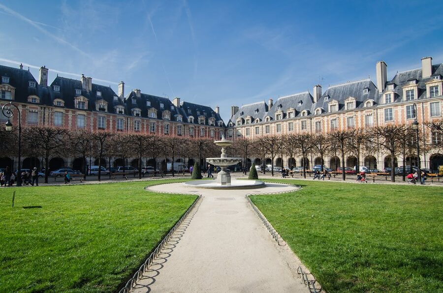 Place des Vosges square in Paris with fountain and architecture