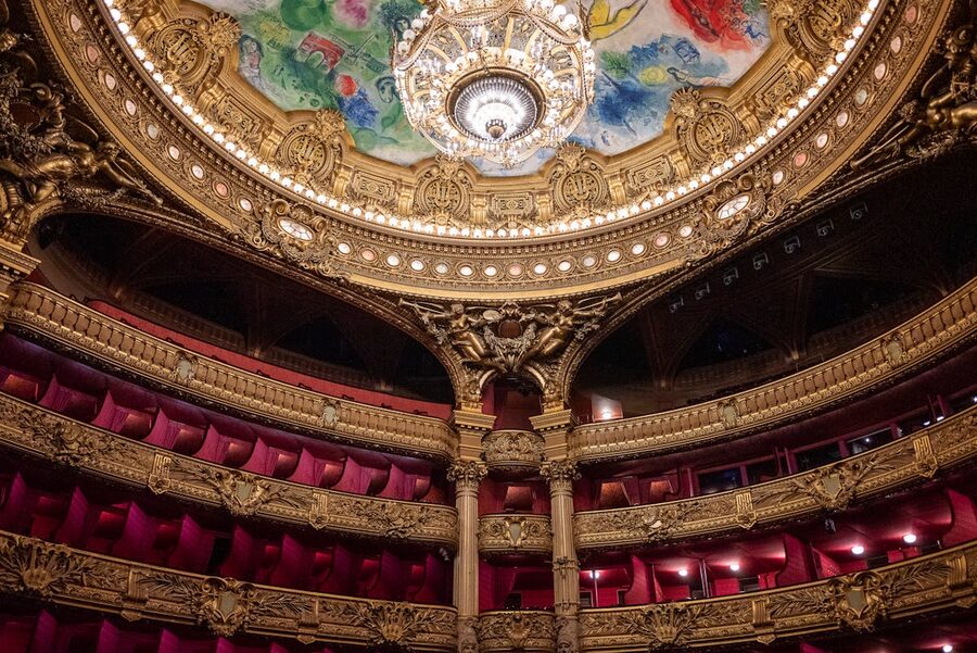 Ornate Paris theater interior with gold details and chandelier