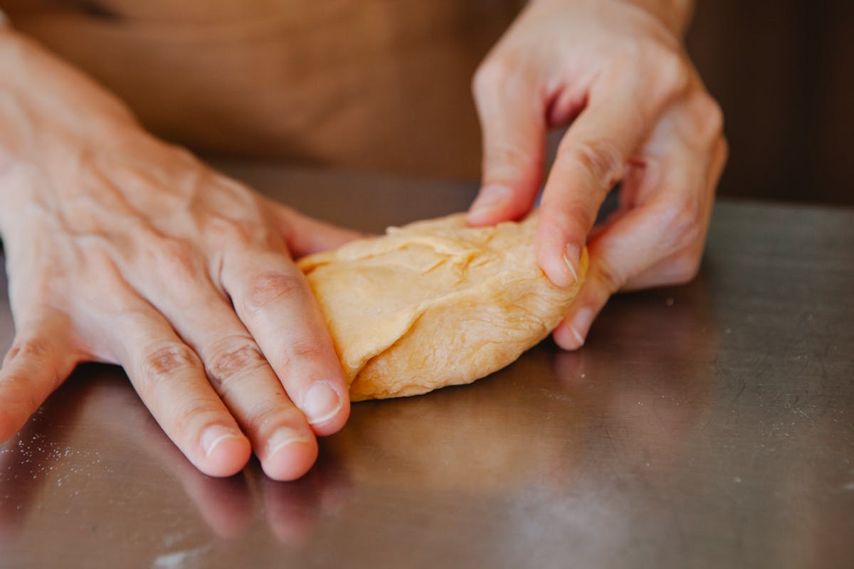 Hands kneading fresh pasta dough during a cooking class