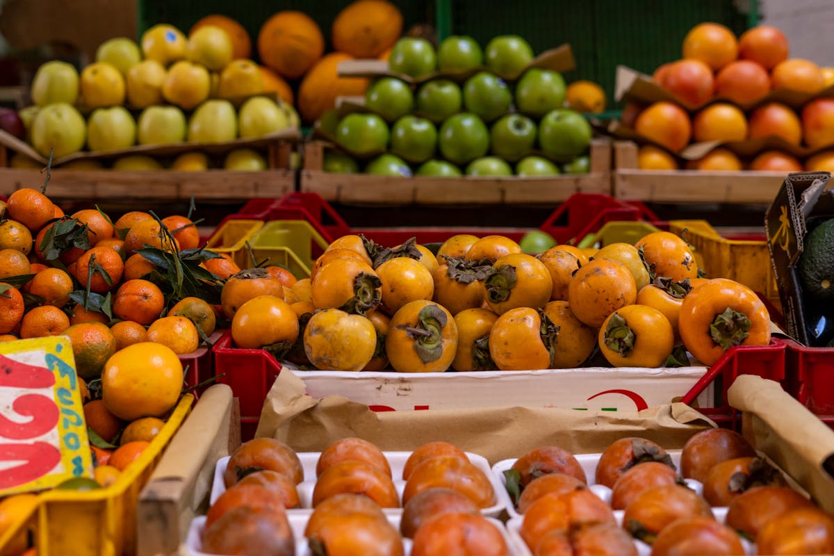Fresh persimmons and tangerines at a market stall in Rome