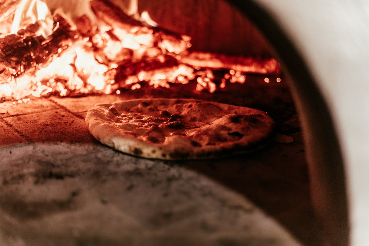 Pizza baking in a traditional wood-fired oven