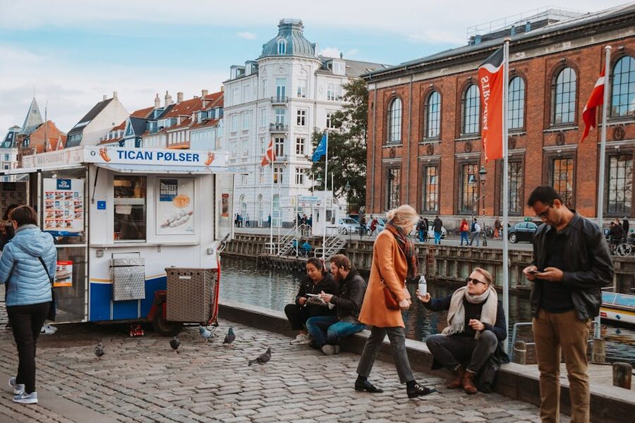 Locals enjoying food and drinks by a Copenhagen canal