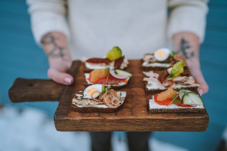 Open-faced sandwiches with various toppings on a wooden board