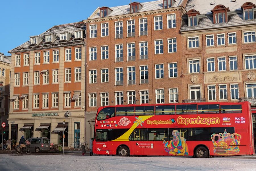 Red Sightseeing bus passing Copenhagen historic architecture in winter