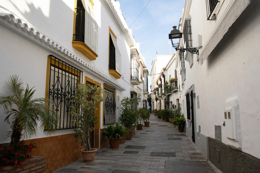 Whitewashed Andalusian street lined with potted plants in Cordoba old town