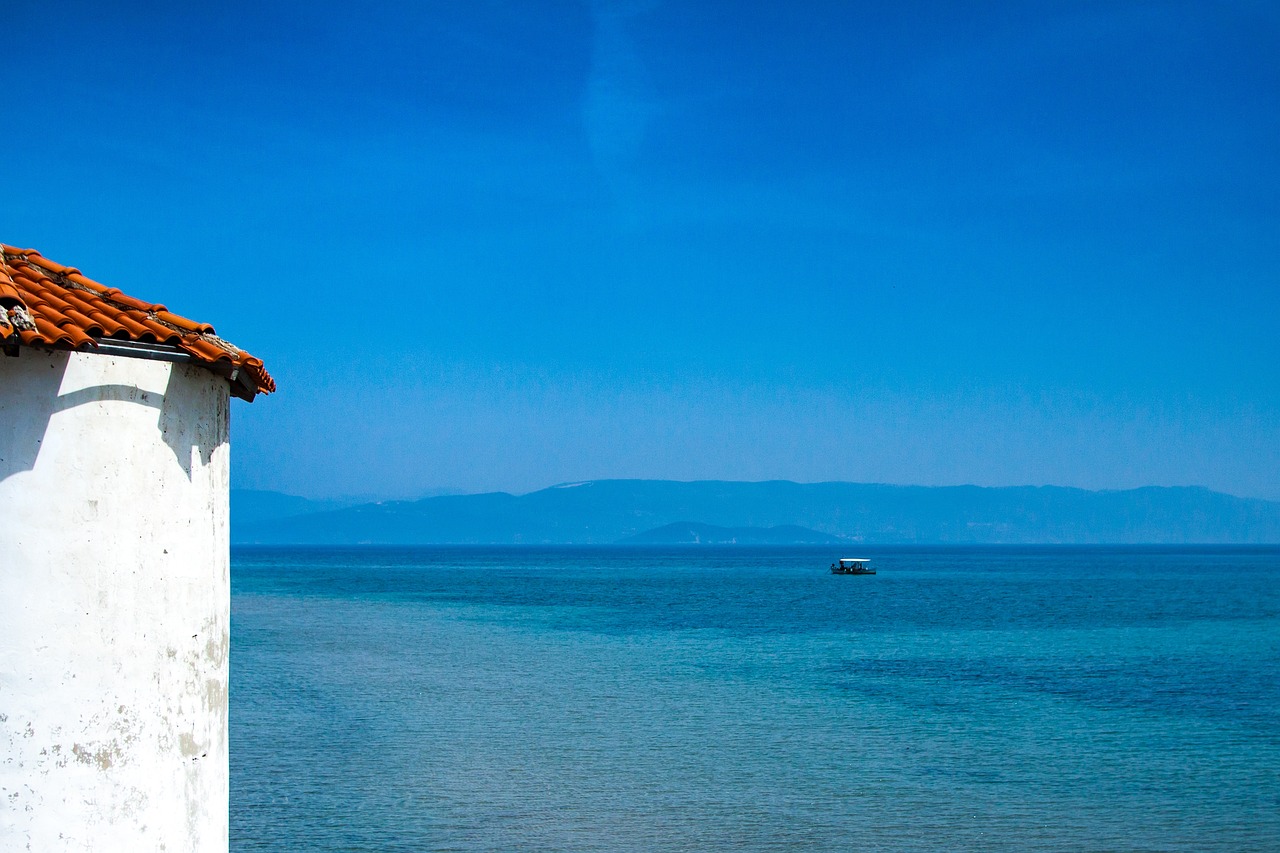 A fishing boat moored near the Corfu coast with green mountains in the background