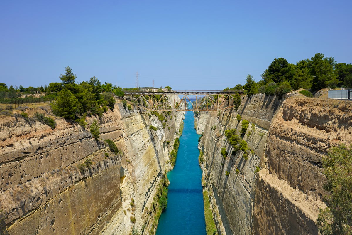 The narrow Corinth Canal in Greece with bright blue water and steep rock walls