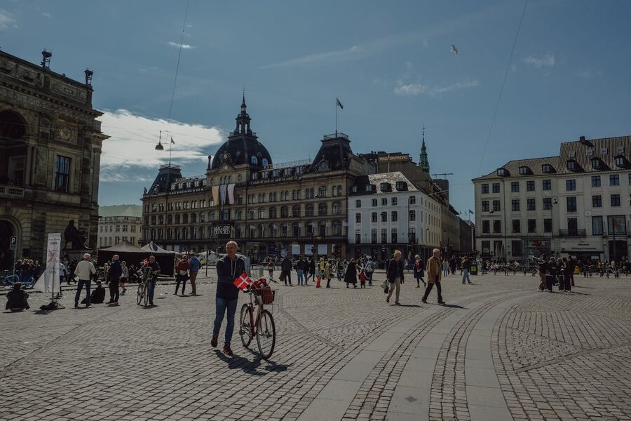 Scenic view of a city square in Copenhagen with historical buildings and people