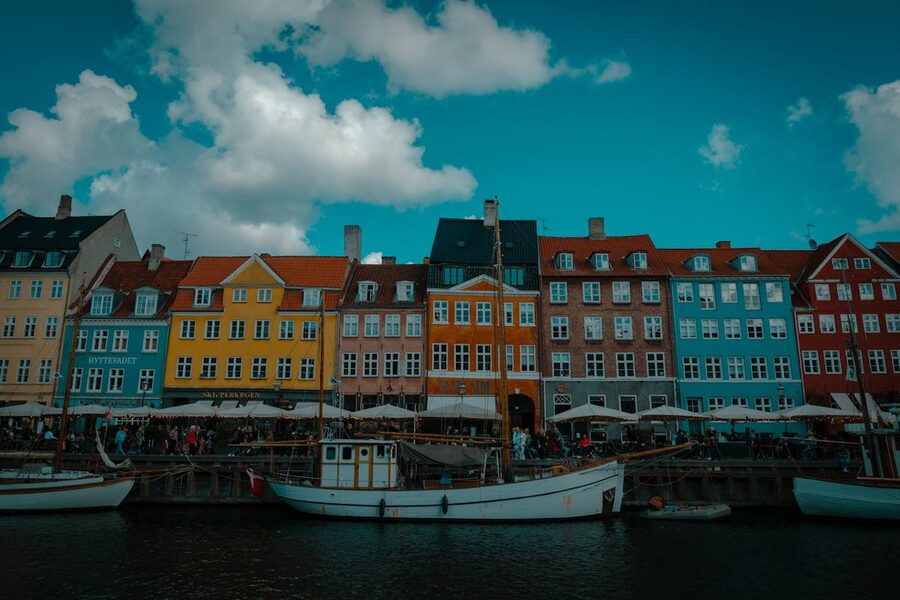 Historic boats and colorful buildings lining the Nyhavn canal in Copenhagen Denmark