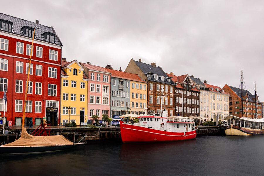 Scenic view of colorful buildings and boats docked along Nyhavn canal Copenhagen
