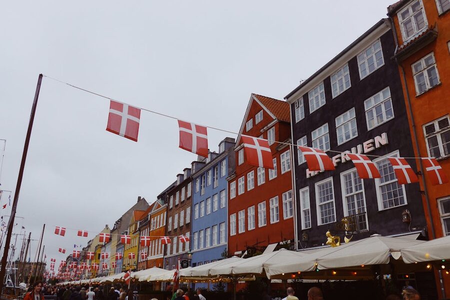 Nyhavn district in Copenhagen adorned with Danish flags and historic buildings