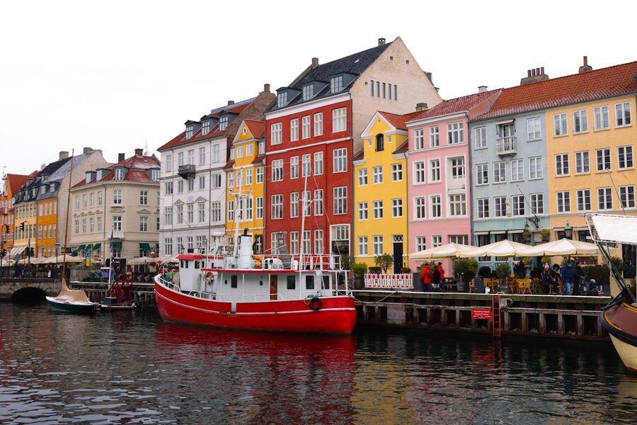 Brightly colored buildings line the Nyhavn harbor in Copenhagen Denmark