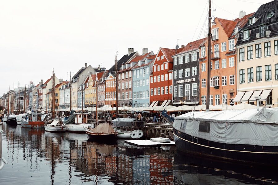 Colorful buildings reflected in Nyhavn canal water with moored boats Copenhagen