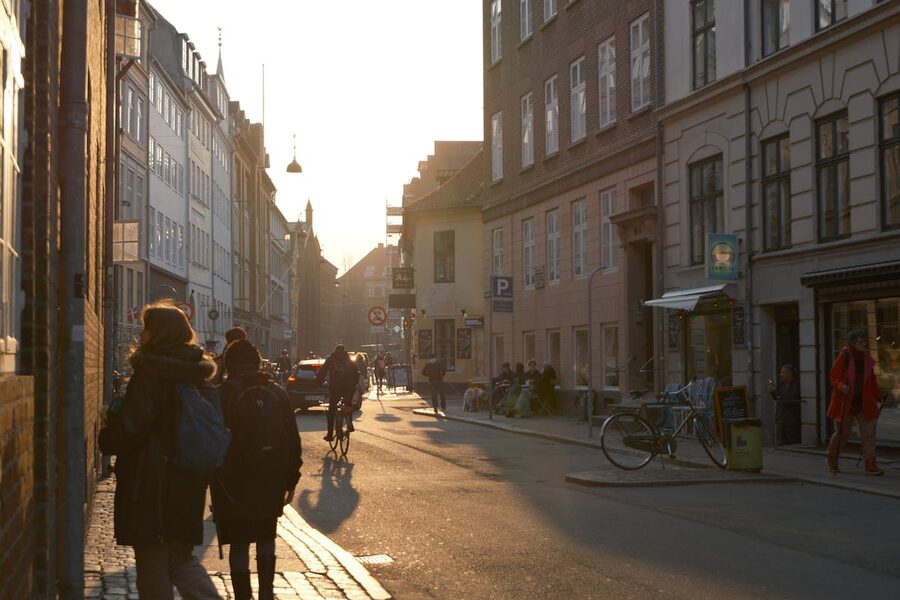 Sunlit street in Copenhagen at sunset with cyclist and pedestrians