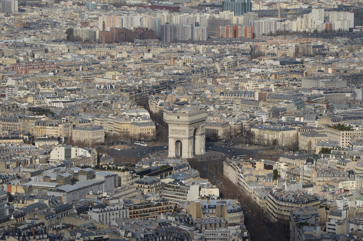 Aerial view of the Arc de Triomphe surrounded by the Paris cityscape