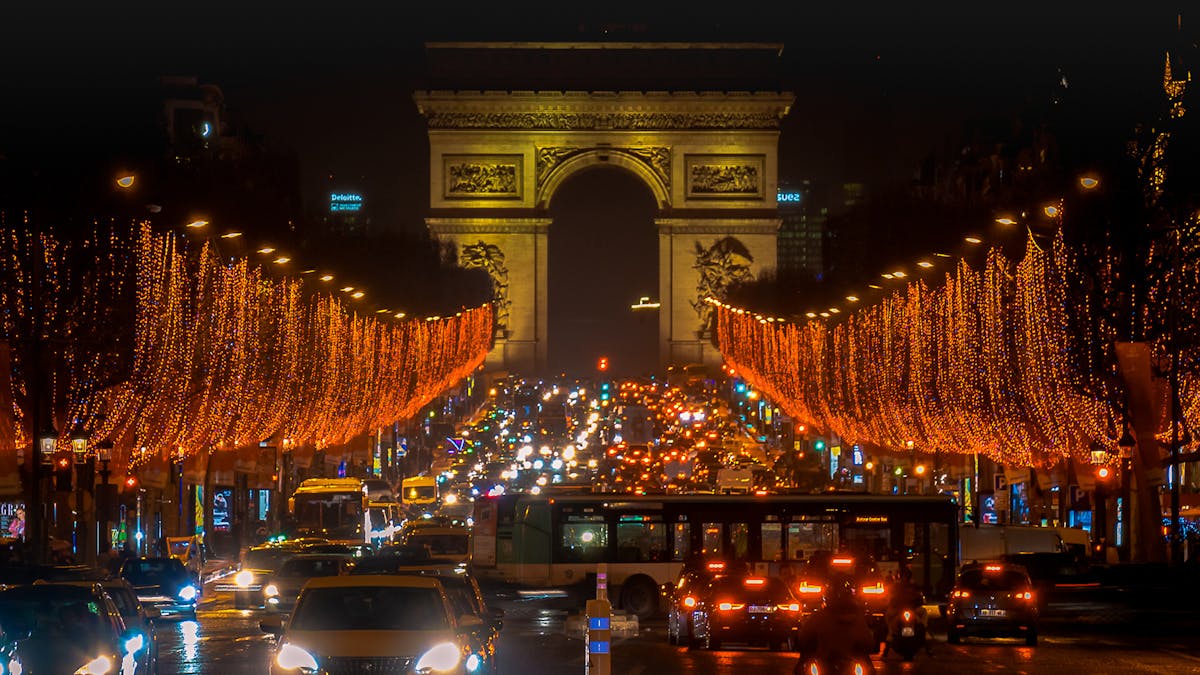 The Champs-Elysees at night with the Arc de Triomphe illuminated in the background