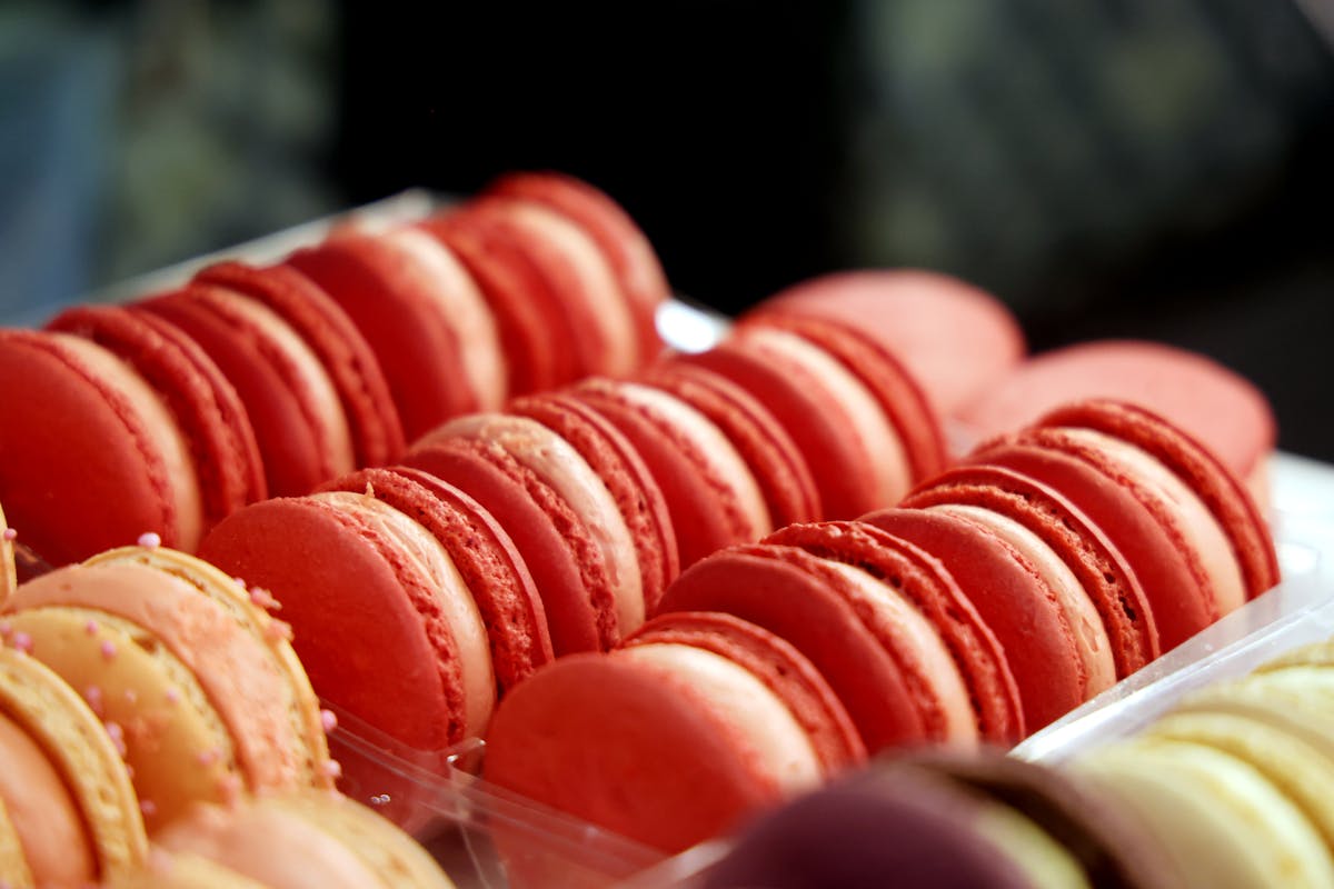 Close-up of colourful French macarons arranged in rows